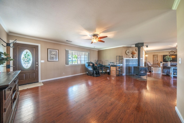 entrance foyer with a wood stove, visible vents, ceiling fan, and wood finished floors