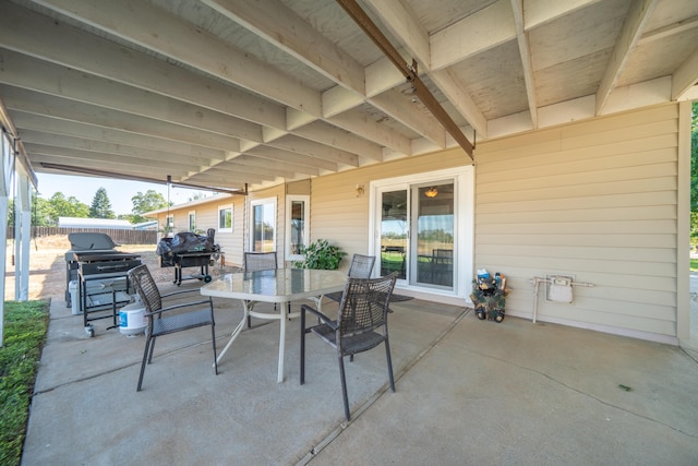 view of patio featuring area for grilling, outdoor dining area, and fence