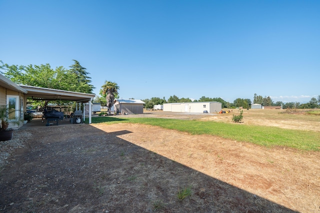 view of yard featuring an outbuilding and a carport