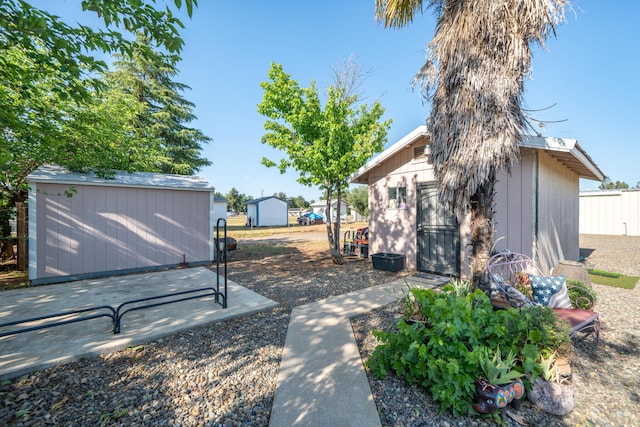 view of yard with fence, a storage shed, and an outdoor structure