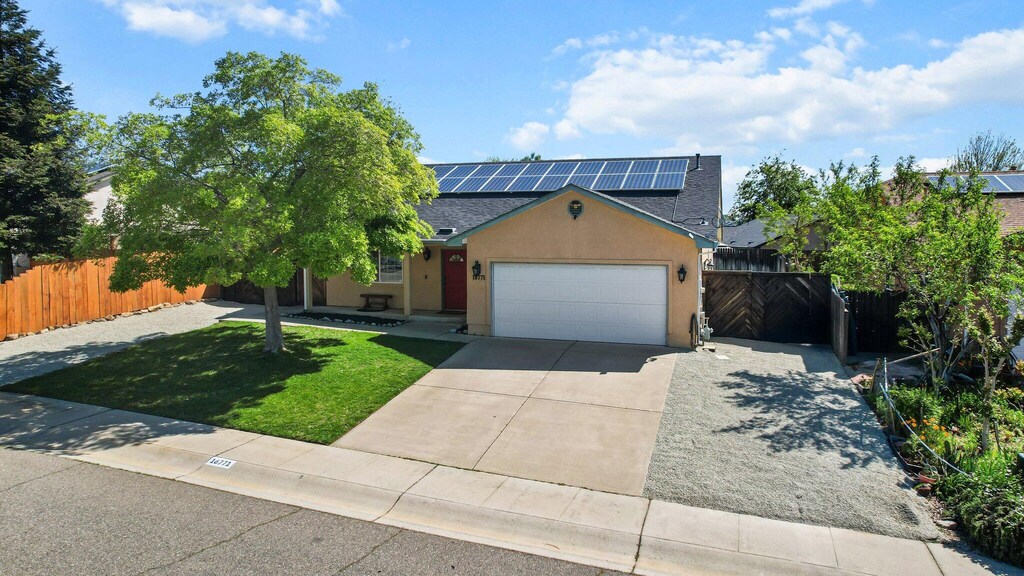 16771 Cape Cod Dr, Redding, CA 96003 - view of front facade with concrete driveway, stucco siding, an attached garage, a front yard, and fence