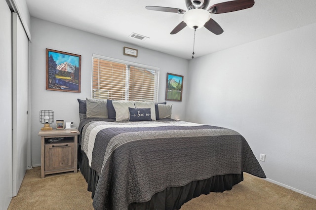 bedroom with visible vents, baseboards, a closet, and light colored carpet