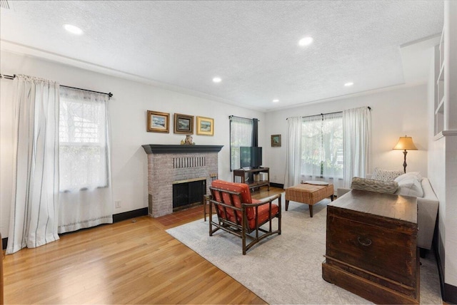 living room featuring recessed lighting, plenty of natural light, wood finished floors, and a textured ceiling