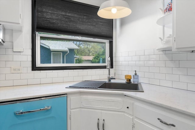 kitchen with light countertops, a sink, and white cabinets