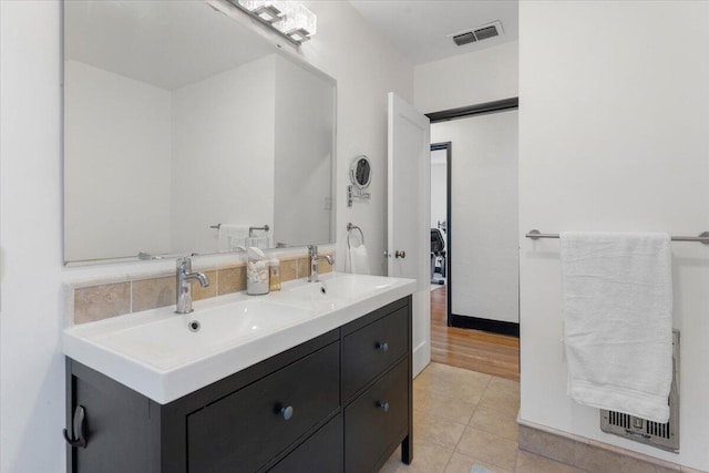 bathroom with a sink, visible vents, tile patterned floors, and double vanity