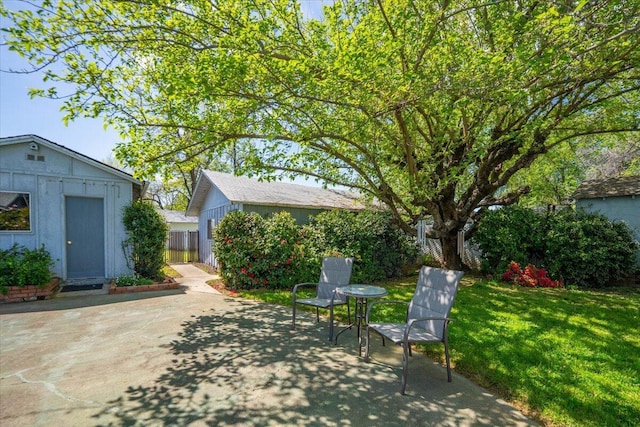 view of patio / terrace featuring an outbuilding and fence