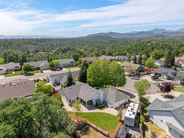 birds eye view of property with a mountain view, a residential view, and a view of trees