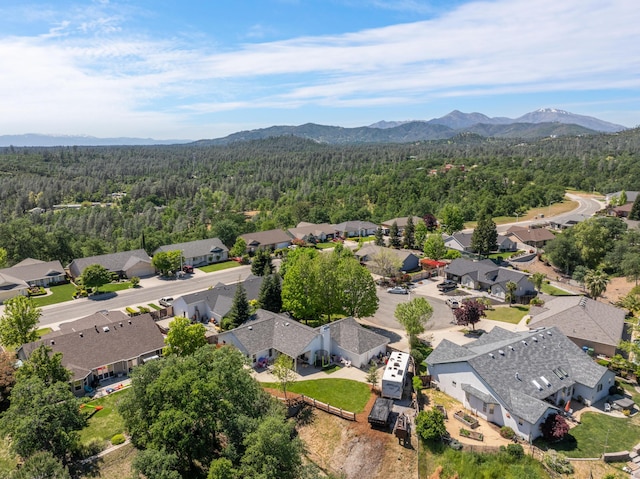 drone / aerial view with a mountain view, a residential view, and a view of trees