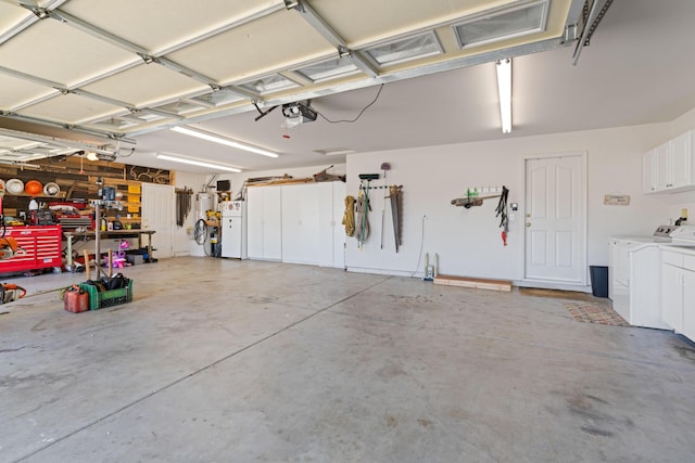 garage with a garage door opener, a workshop area, separate washer and dryer, and freestanding refrigerator
