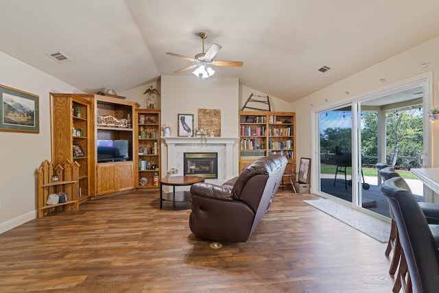living room featuring lofted ceiling, visible vents, a ceiling fan, and dark wood finished floors