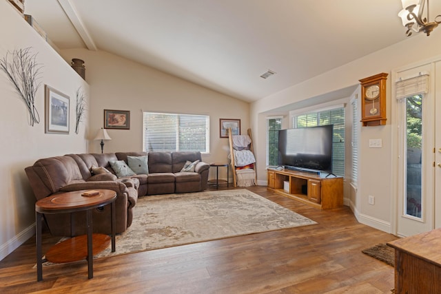living room featuring lofted ceiling with beams, a wealth of natural light, and wood finished floors