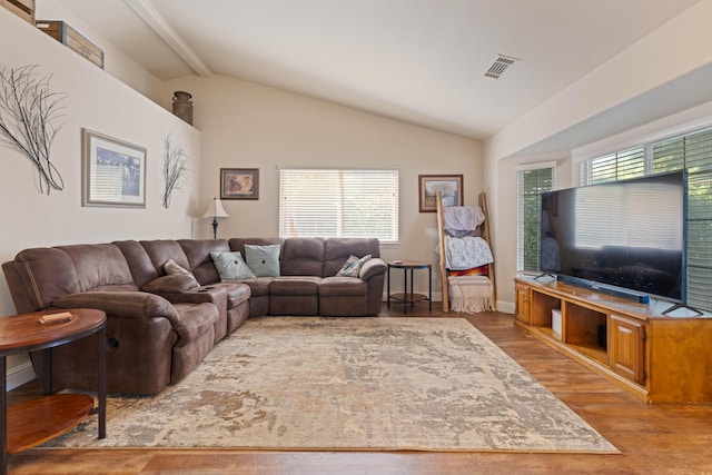 living room with baseboards, visible vents, wood finished floors, and lofted ceiling with beams