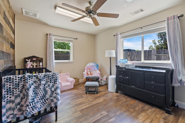 bedroom featuring visible vents, ceiling fan, wood finished floors, and baseboards