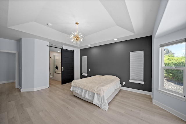 2120 Tradition Way, Redding, CA 96001 - bedroom featuring a tray ceiling, a barn door, and light wood-style floors