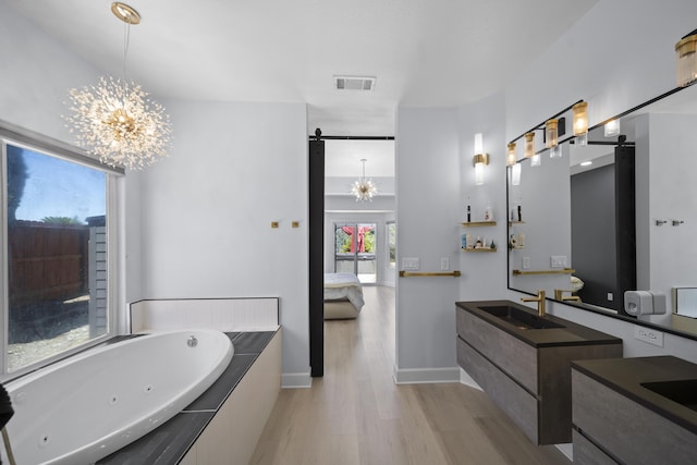 2120 Tradition Way, Redding, CA 96001 - ensuite bathroom with a chandelier, a jetted tub, wood finished floors, and vanity