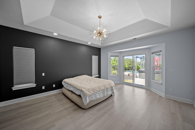 2120 Tradition Way, Redding, CA 96001 - bedroom featuring a tray ceiling, access to outside, a chandelier, and wood finished floors