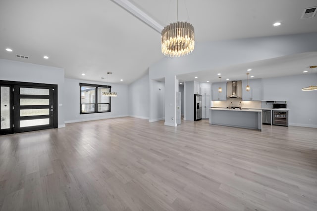 2120 Tradition Way, Redding, CA 96001 - unfurnished living room featuring a chandelier, lofted ceiling, beverage cooler, light wood-style floors, and recessed lighting