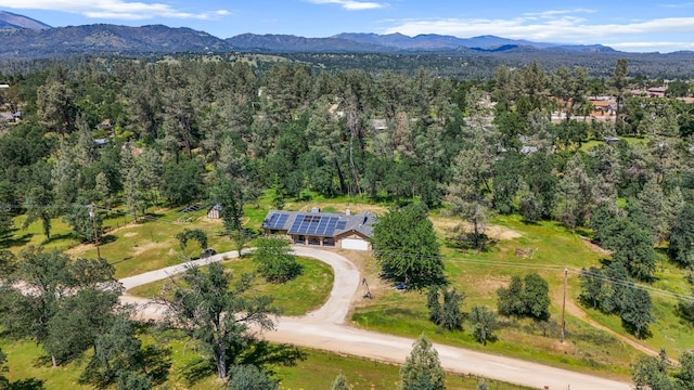 drone / aerial view with a wooded view and a mountain view