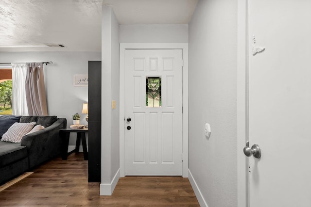 entrance foyer featuring dark wood-style floors, visible vents, and baseboards