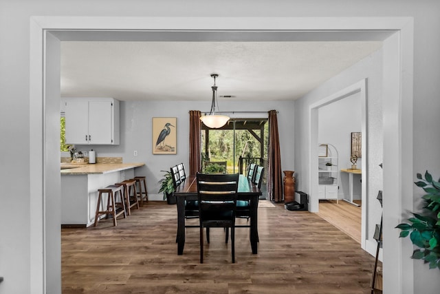 dining area featuring baseboards and dark wood-style flooring