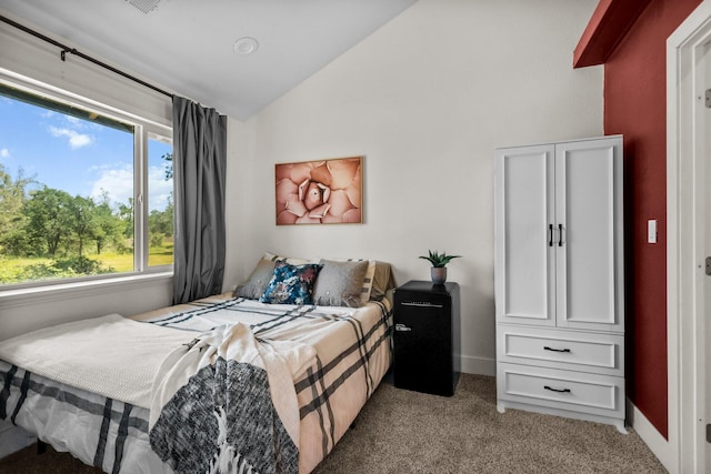 carpeted bedroom featuring lofted ceiling and baseboards