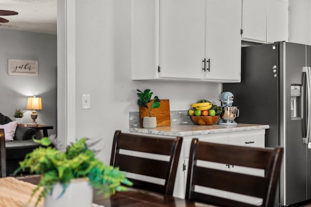 kitchen featuring ceiling fan, white cabinetry, stainless steel fridge with ice dispenser, and light countertops