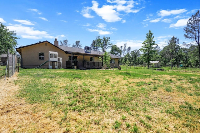 rear view of property featuring a yard and fence