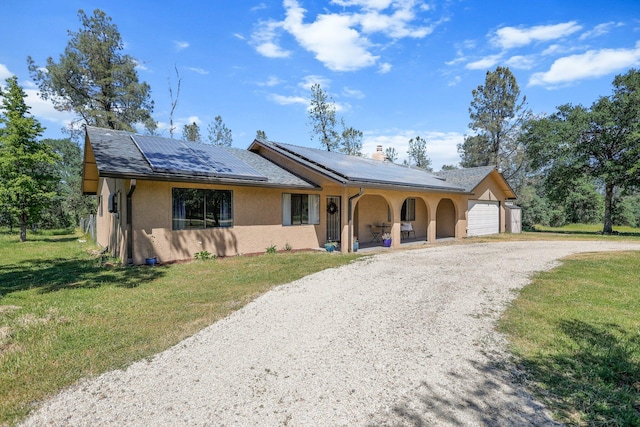 ranch-style house featuring stucco siding, covered porch, gravel driveway, and a front lawn