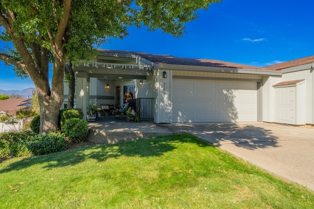 ranch-style house featuring an attached garage, a front lawn, and concrete driveway