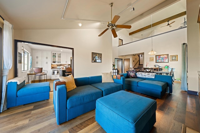 living area featuring high vaulted ceiling, a ceiling fan, and wood finished floors
