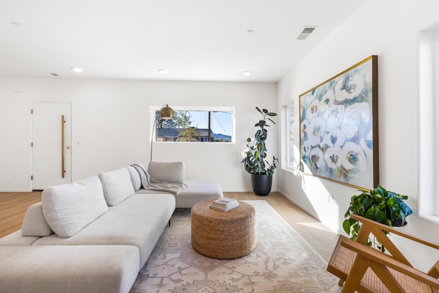 living area featuring recessed lighting, light wood-type flooring, and visible vents