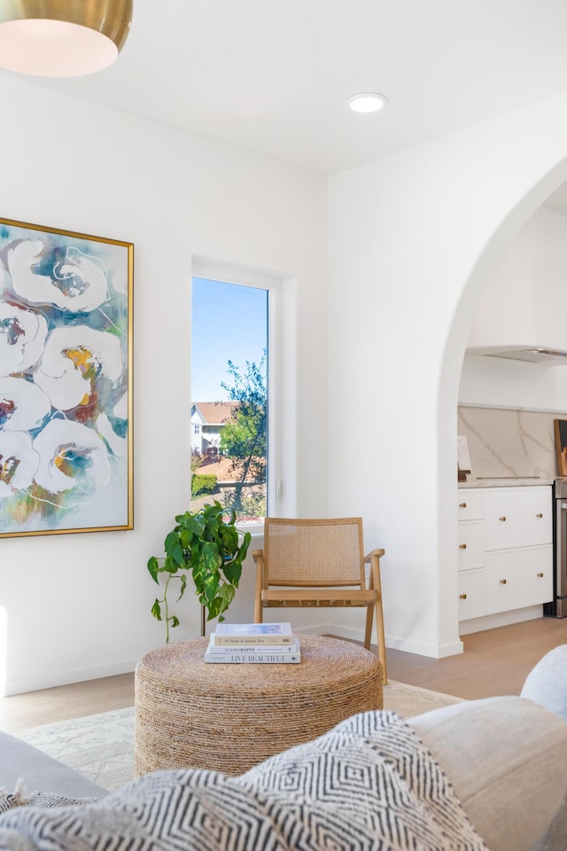 bedroom with baseboards, arched walkways, light wood-style floors, and recessed lighting