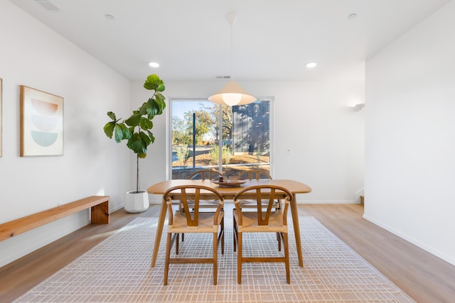 dining room with baseboards, light wood-style floors, visible vents, and recessed lighting