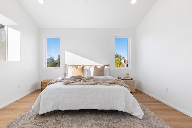 bedroom featuring lofted ceiling, wood finished floors, and recessed lighting