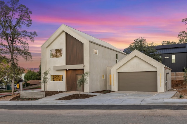contemporary house featuring stucco siding, driveway, and a garage