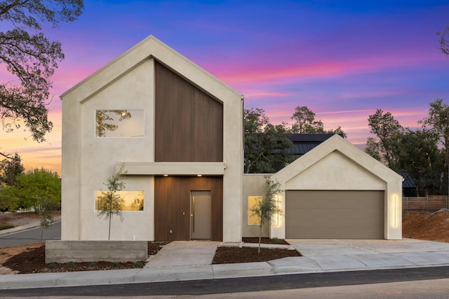 contemporary home featuring an attached garage, driveway, and stucco siding