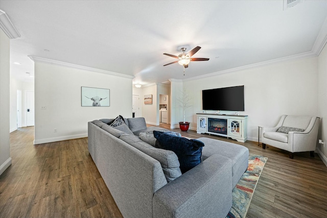 living room featuring ornamental molding, a ceiling fan, baseboards, and dark wood-style flooring