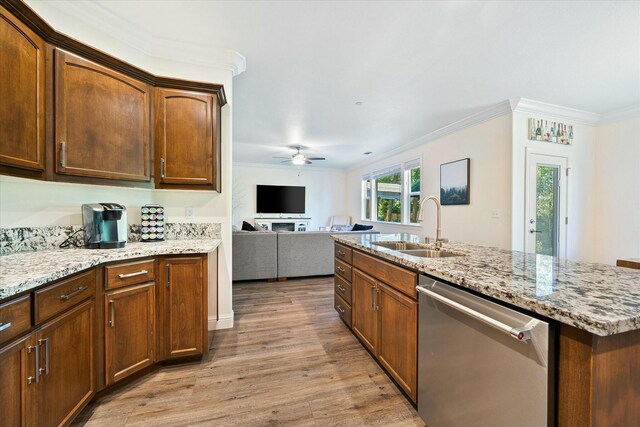 kitchen with a sink, light wood-style floors, a ceiling fan, crown molding, and dishwasher