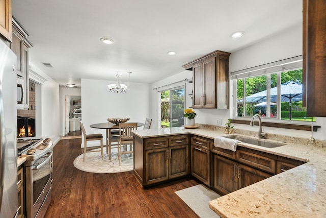 6860 Riata Dr, Redding, CA 96002 - kitchen with stainless steel range with gas cooktop, a peninsula, a sink, and dark wood finished floors