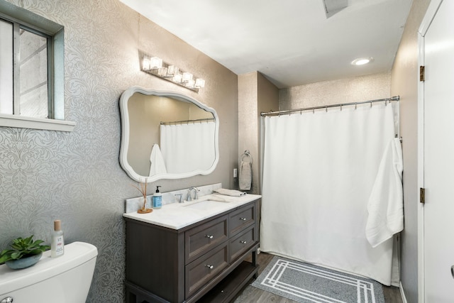 6860 Riata Dr, Redding, CA 96002 - full bathroom featuring wood finished floors, wallpapered walls, vanity, curtained shower, and toilet