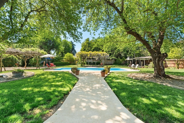 6860 Riata Dr, Redding, CA 96002 - view of home's community with a lawn, a fenced backyard, a pool, and a patio area