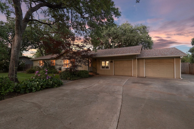 7057 Riata Dr, Redding, CA 96002 - ranch-style house with a garage, concrete driveway, fence, and roof with shingles
