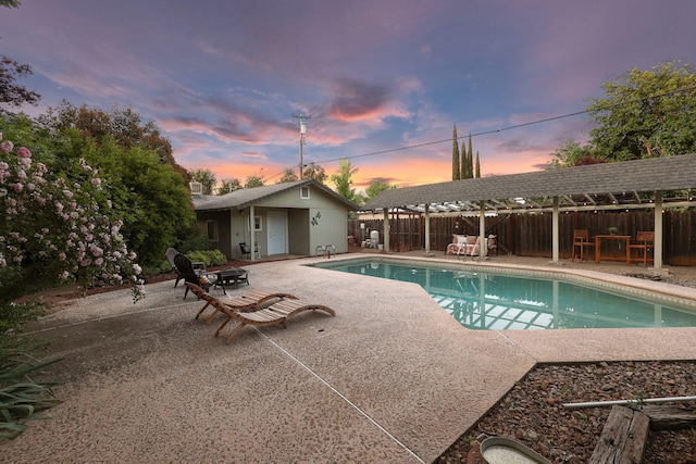 7057 Riata Dr, Redding, CA 96002 - pool at dusk featuring a patio area and a fenced backyard