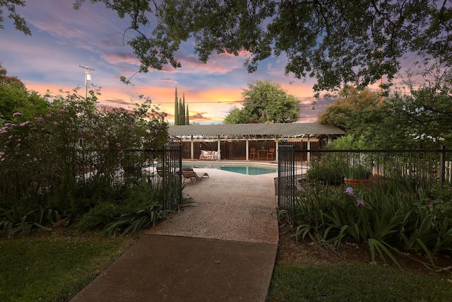 7057 Riata Dr, Redding, CA 96002 - pool at dusk featuring a patio area and fence