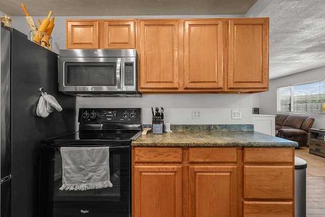 4647 County Road Ff, Orland, CA 95963 - kitchen with black appliances, dark countertops, a textured ceiling, and brown cabinetry