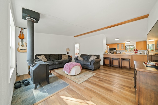living room with light wood-type flooring and a wood stove