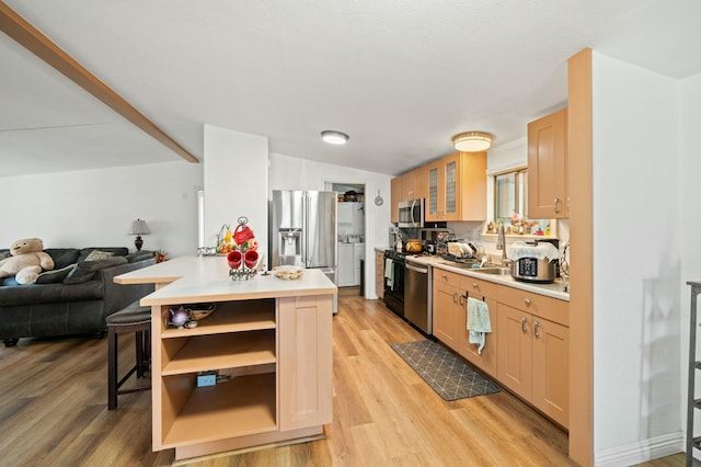kitchen featuring light wood finished floors, stainless steel appliances, light countertops, and open shelves