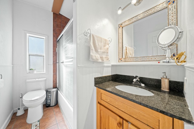 bathroom featuring tile patterned floors, a wainscoted wall, vanity, and toilet