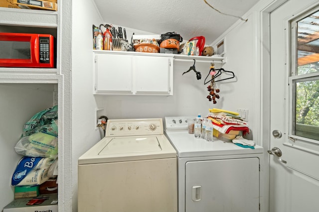 laundry area with separate washer and dryer, cabinet space, and a textured ceiling