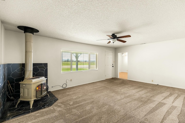 21623 Seven Lakes Ln, Redding, CA 96003 - unfurnished living room with ceiling fan, carpet floors, a textured ceiling, and a wood stove